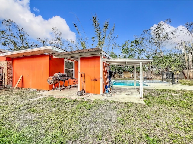 view of outdoor structure featuring a lawn and a fenced in pool