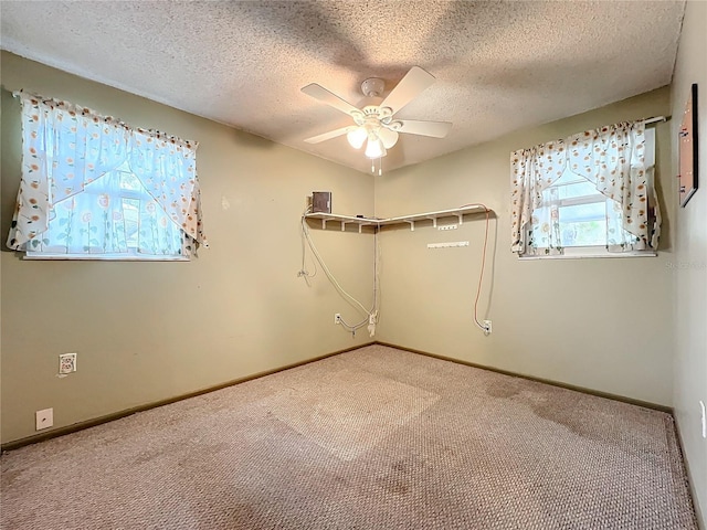 empty room featuring a textured ceiling, ceiling fan, and carpet floors