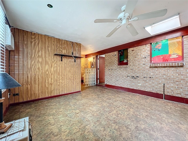 unfurnished living room with ceiling fan, brick wall, and wooden walls