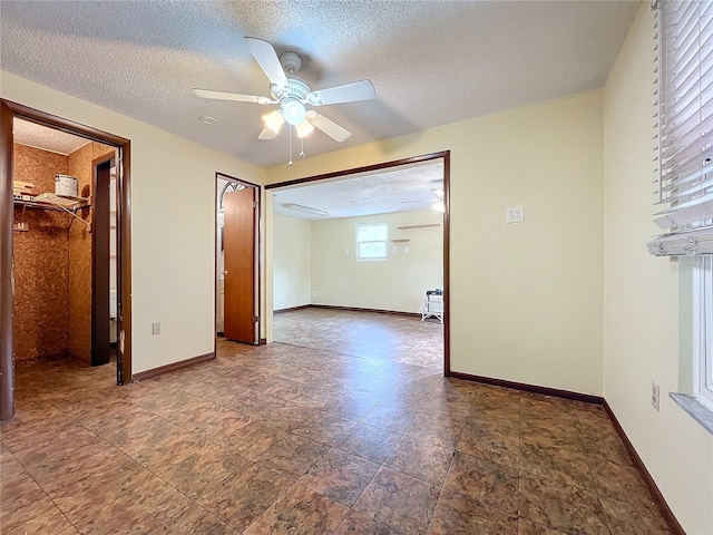 spare room featuring a textured ceiling and ceiling fan