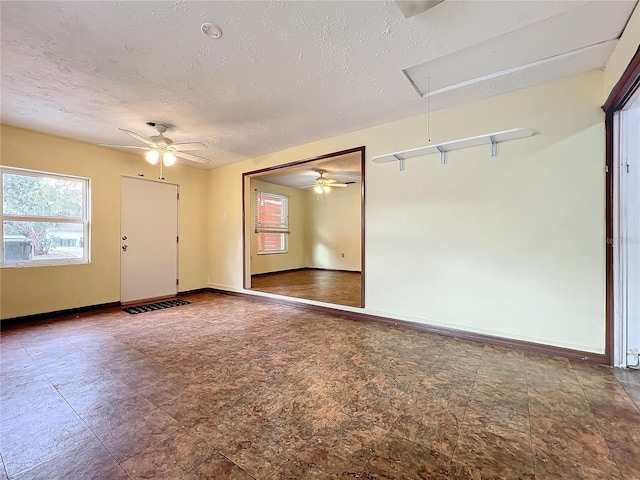 spare room with ceiling fan and a textured ceiling