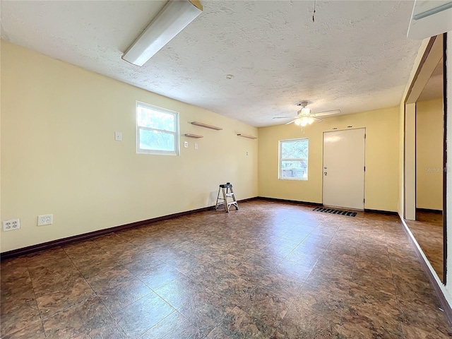 empty room featuring a textured ceiling and ceiling fan