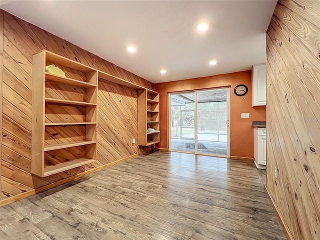 unfurnished living room with wood walls and hardwood / wood-style flooring