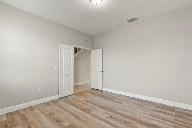 unfurnished bedroom featuring light hardwood / wood-style flooring and a textured ceiling