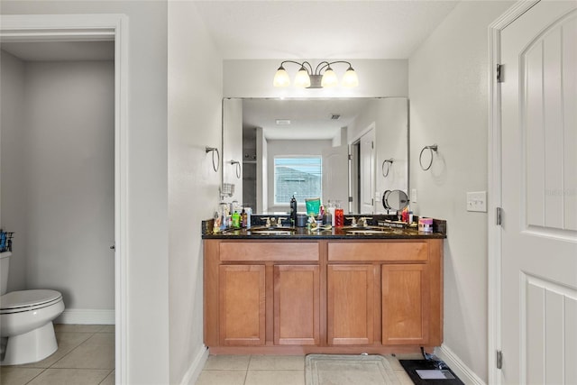 bathroom with toilet, tile patterned flooring, and vanity