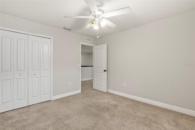 unfurnished bedroom featuring light carpet, a closet, and ceiling fan