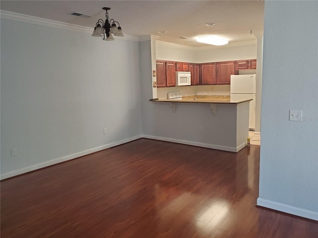 kitchen featuring kitchen peninsula, a kitchen bar, crown molding, and white appliances