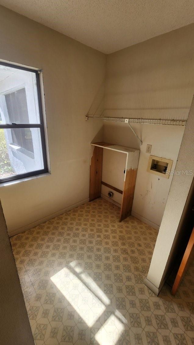 laundry area featuring washer hookup and a textured ceiling