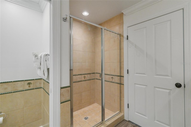 bathroom featuring a shower with door, ornamental molding, and hardwood / wood-style flooring