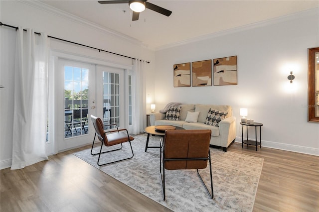 living room featuring crown molding, french doors, ceiling fan, and light wood-type flooring