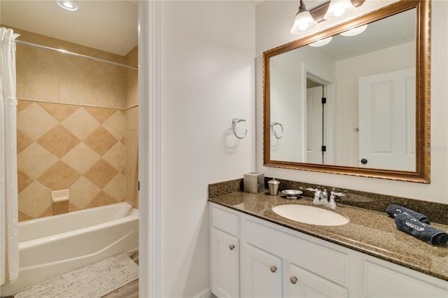 bathroom featuring tiled shower / bath and vanity