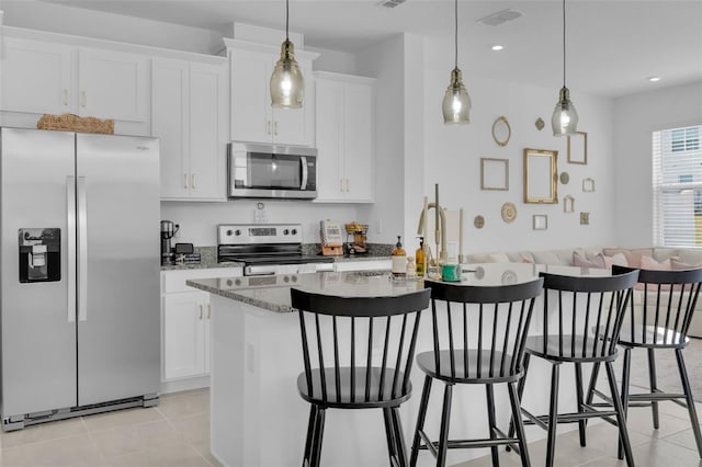 kitchen with stainless steel appliances, pendant lighting, and white cabinetry