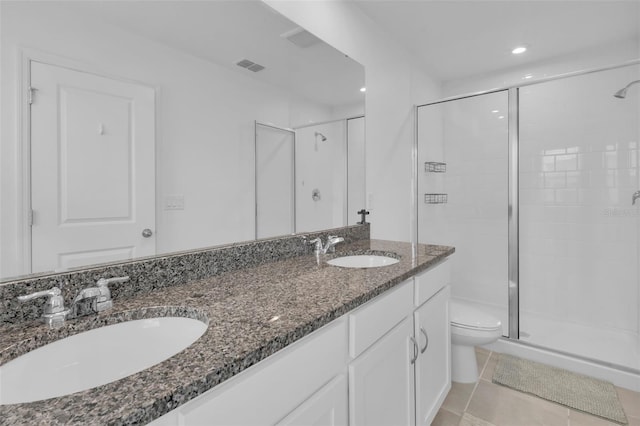 bathroom with toilet, walk in shower, vanity, and tile patterned flooring