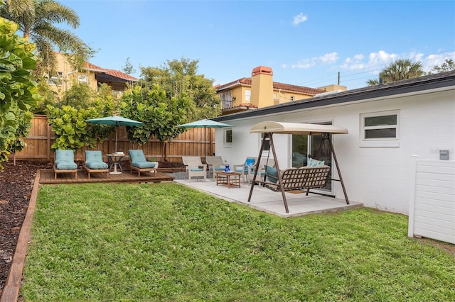 back of house with fence, outdoor lounge area, a lawn, and a patio