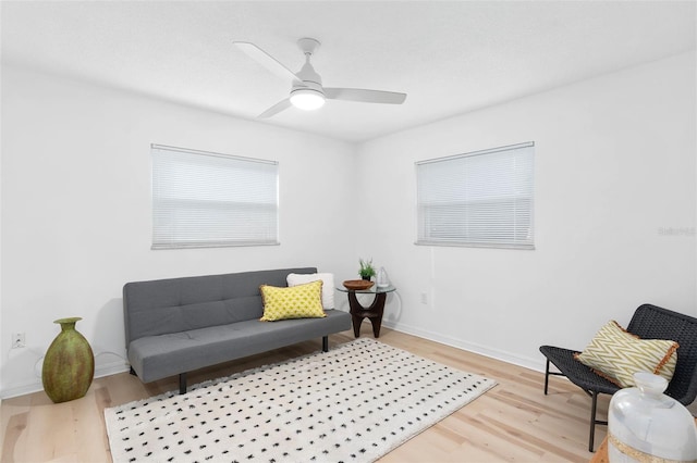 sitting room with ceiling fan, light wood finished floors, and baseboards