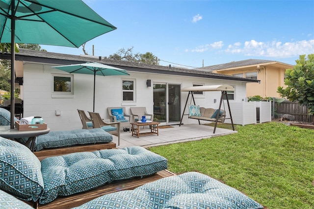 rear view of property featuring a yard, a patio area, fence, and an outdoor hangout area