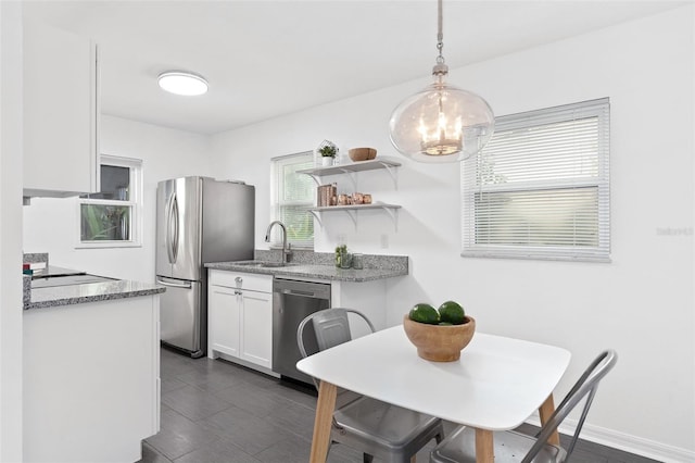 kitchen with stainless steel appliances, a sink, white cabinetry, open shelves, and decorative light fixtures