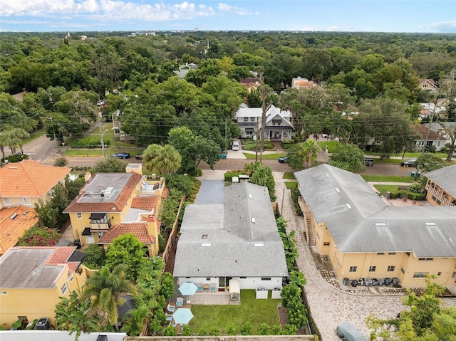 drone / aerial view featuring a residential view and a view of trees