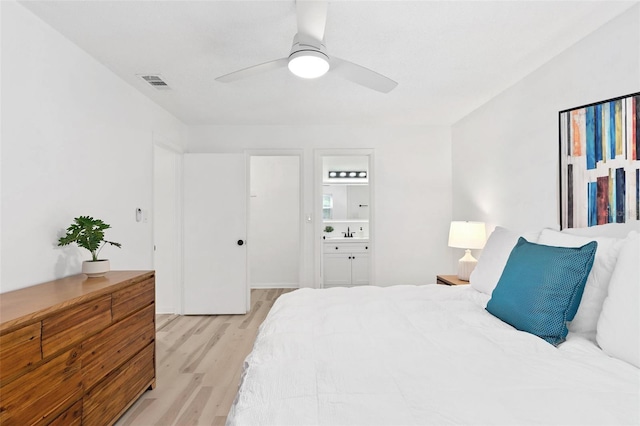 bedroom with ceiling fan, sink, light hardwood / wood-style floors, and ensuite bath