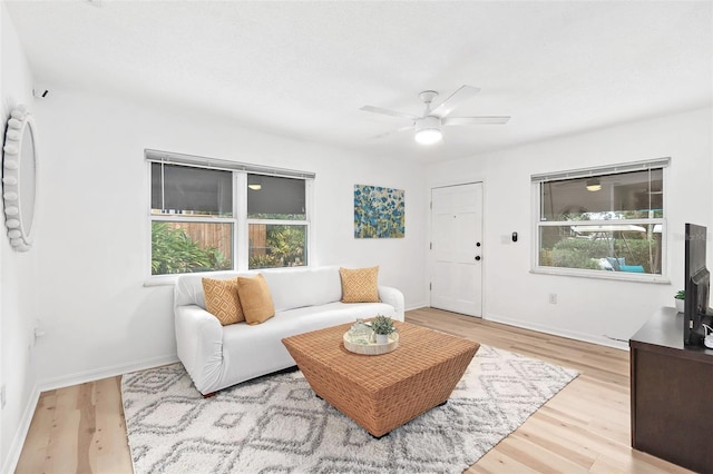 living room featuring ceiling fan, a healthy amount of sunlight, and light wood-type flooring