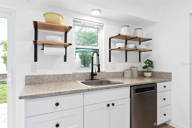 kitchen featuring dishwasher, open shelves, white cabinets, and a sink