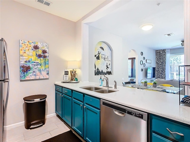 kitchen featuring stainless steel dishwasher, light tile patterned floors, blue cabinets, and sink