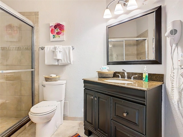 bathroom with toilet, vanity, an enclosed shower, and tile patterned floors