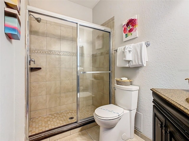 bathroom featuring toilet, vanity, tile patterned flooring, and walk in shower