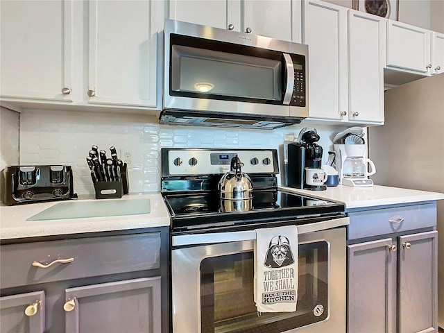 kitchen featuring white cabinets, backsplash, gray cabinetry, and stainless steel appliances