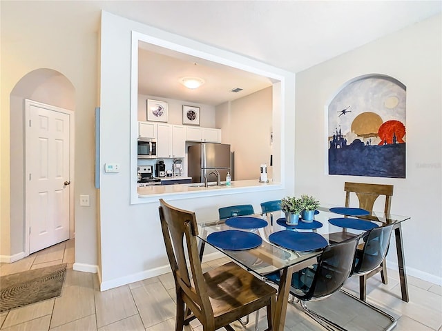 dining area featuring light tile patterned floors and sink