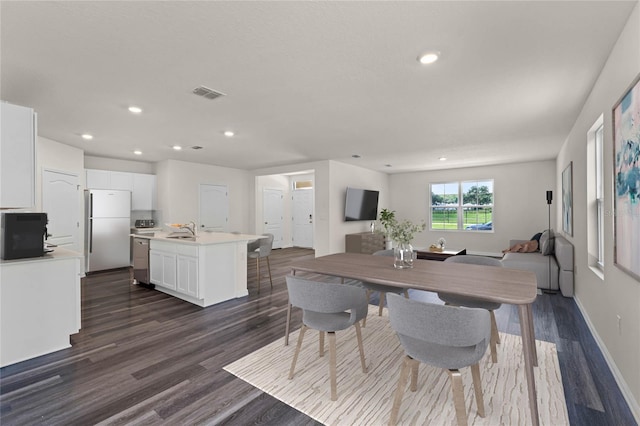 dining space with dark wood-type flooring and sink