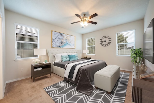 carpeted bedroom with multiple windows and ceiling fan