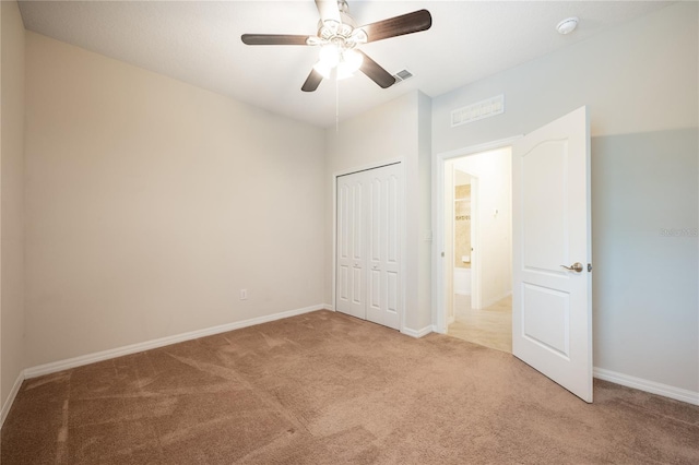 unfurnished bedroom with light colored carpet, ceiling fan, and a closet