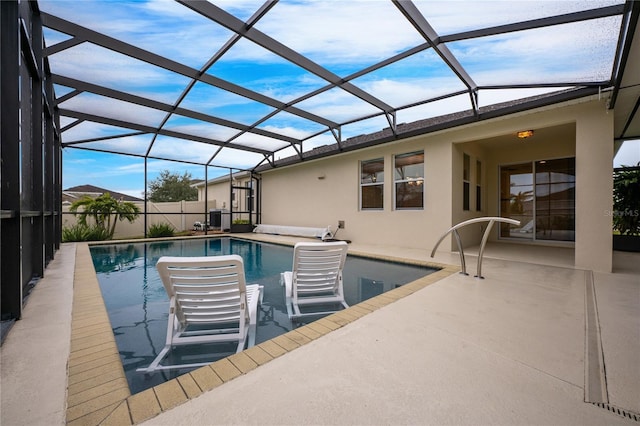 view of pool featuring glass enclosure and a patio area