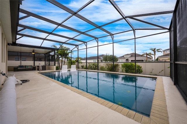 view of pool with outdoor lounge area, a patio, and glass enclosure