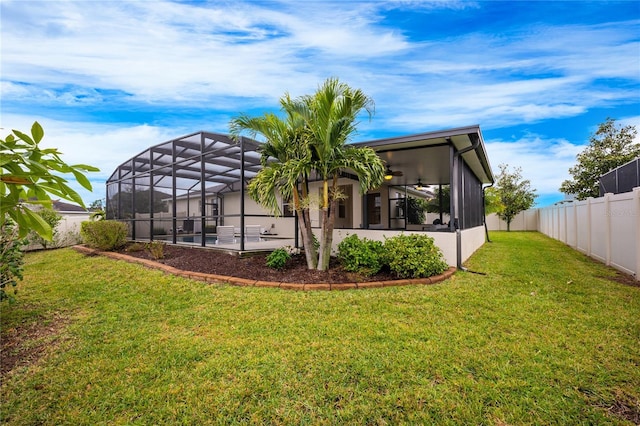 back of property featuring a lanai, a yard, ceiling fan, and a patio area