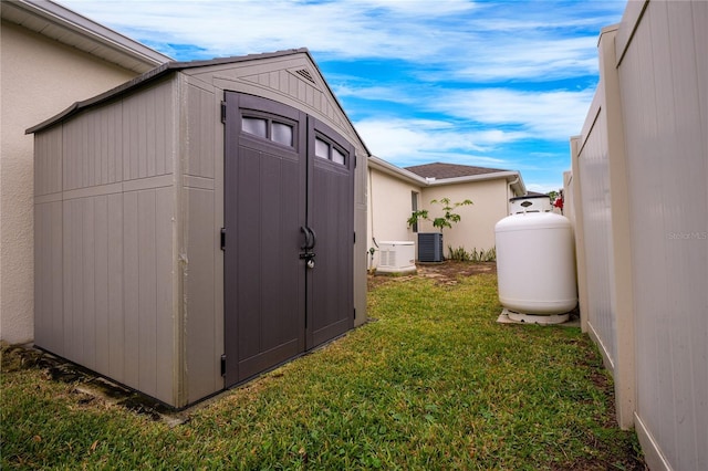 view of outbuilding with a yard and central air condition unit