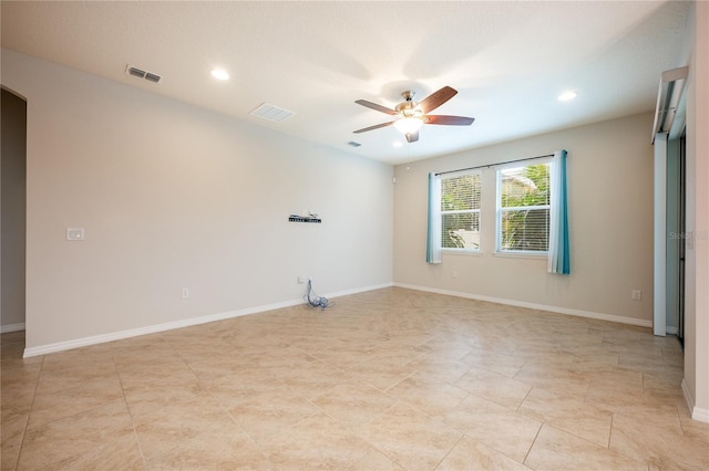 empty room with ceiling fan and light tile patterned flooring