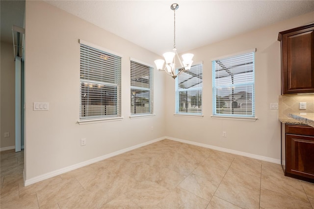 unfurnished dining area with light tile patterned flooring and a chandelier