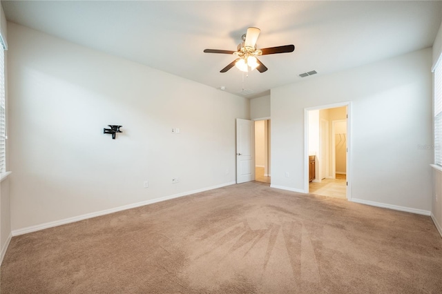 spare room featuring light carpet and ceiling fan