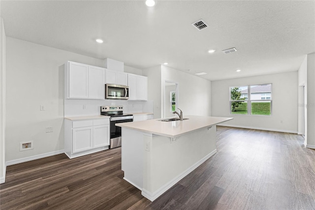 kitchen with sink, white cabinets, stainless steel appliances, and a kitchen island with sink