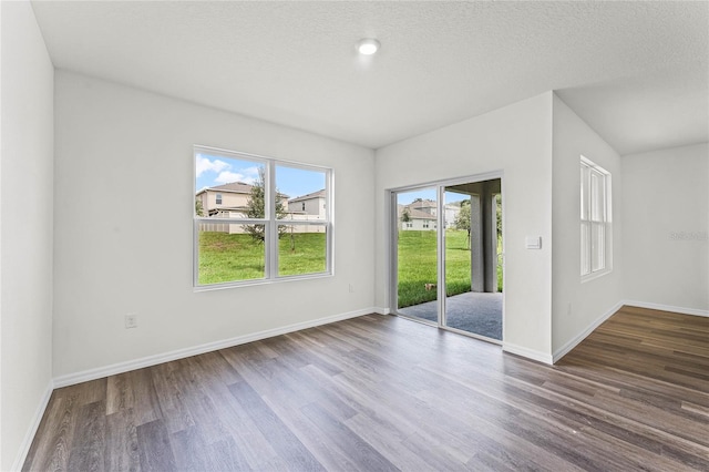 unfurnished room featuring hardwood / wood-style flooring and a textured ceiling