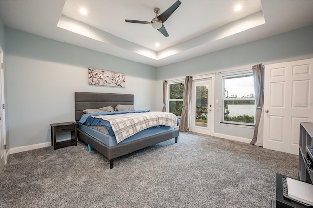 bedroom with carpet, ceiling fan, and a raised ceiling