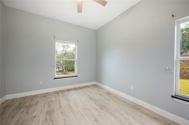 empty room featuring light hardwood / wood-style floors, ceiling fan, and vaulted ceiling