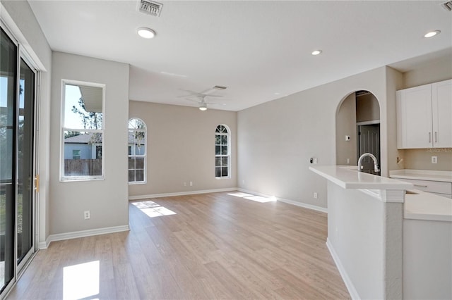 kitchen with ceiling fan, white cabinets, and light wood-type flooring