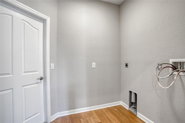 washroom with hookup for an electric dryer, hookup for a washing machine, and hardwood / wood-style floors