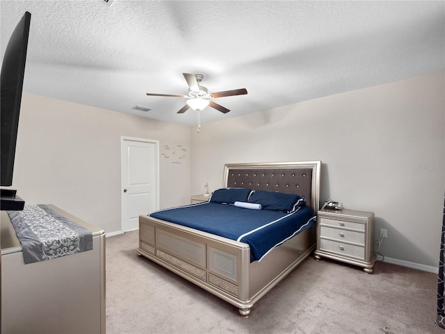 carpeted bedroom featuring a textured ceiling and ceiling fan