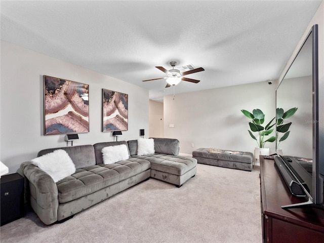 carpeted living room featuring a textured ceiling and ceiling fan