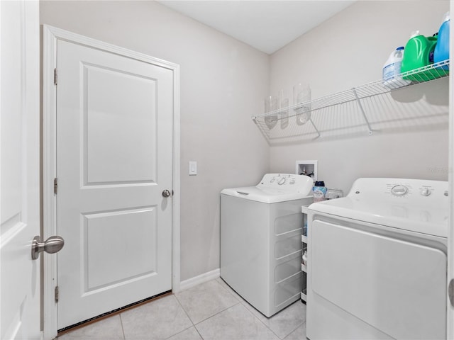 clothes washing area featuring light tile patterned floors and washing machine and clothes dryer