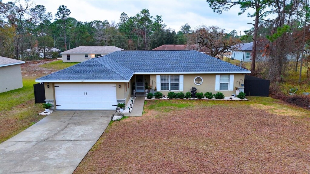 ranch-style house featuring a front lawn and a garage